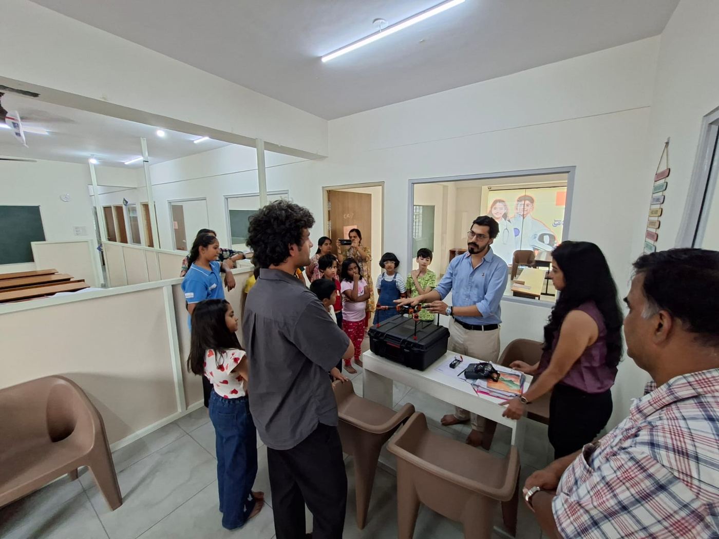 Students and mentors gathered around a drone during a demo