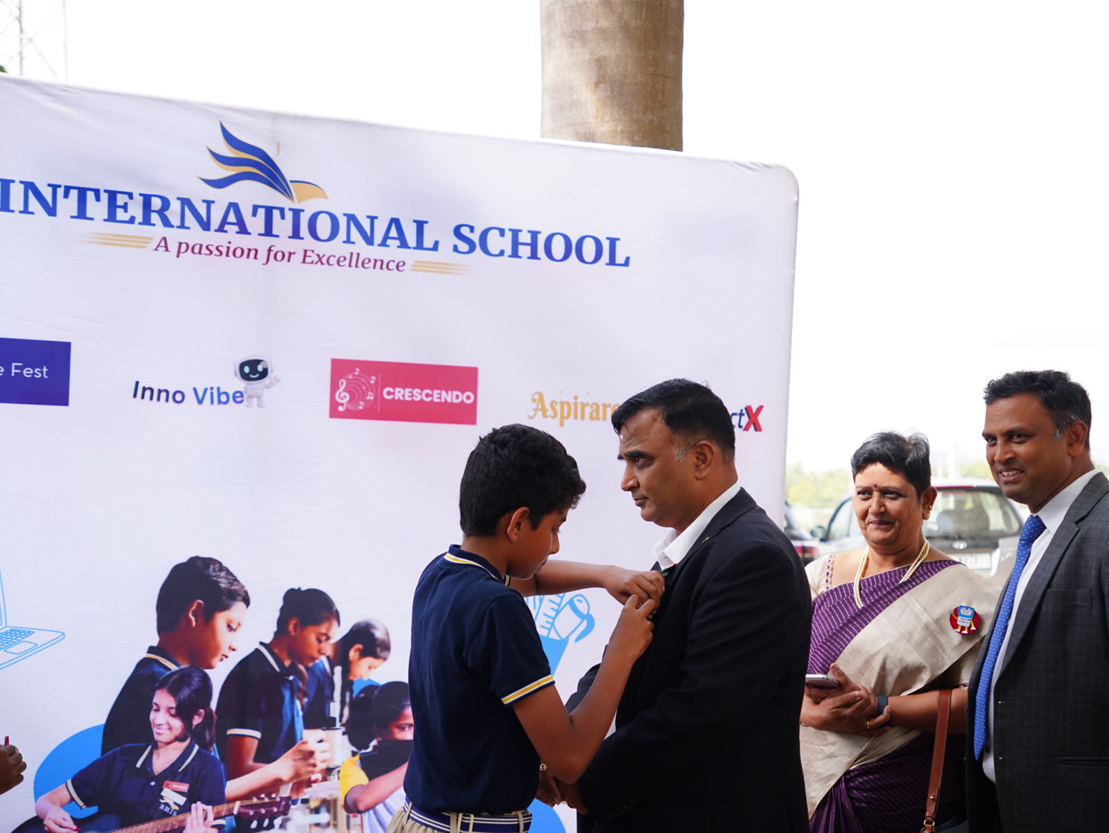 A student pins a badge on a guest at a school robotics event